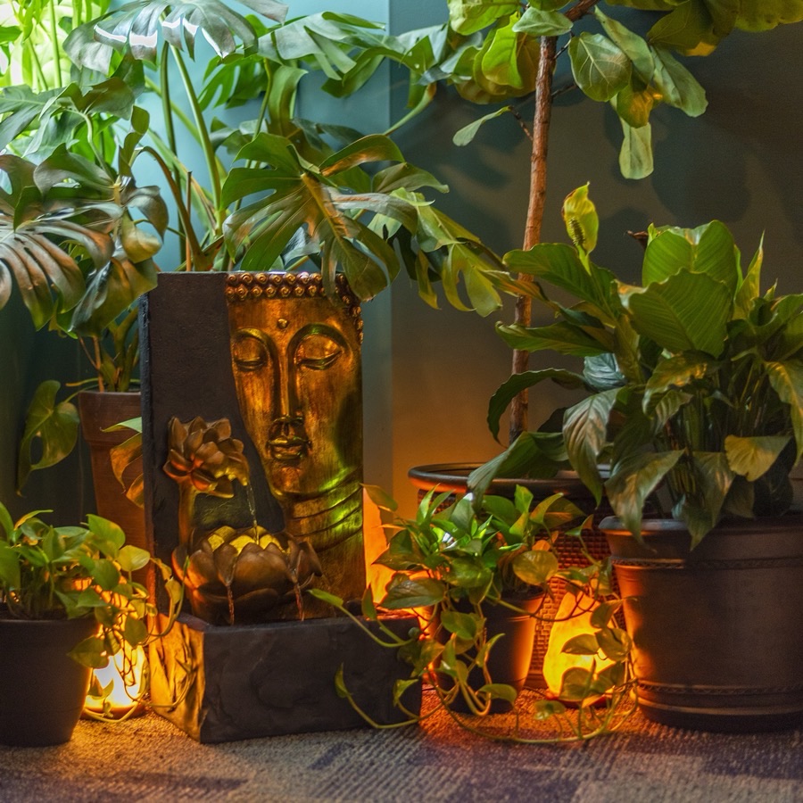 The Buddha fountain at Arash Massage, candlelit among the plants