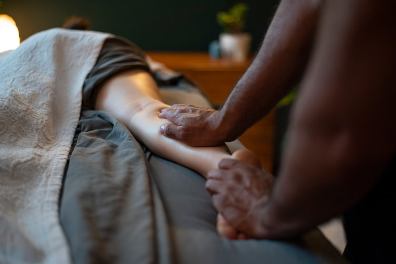 Hands pressing along a guest's forearm resting on the drape